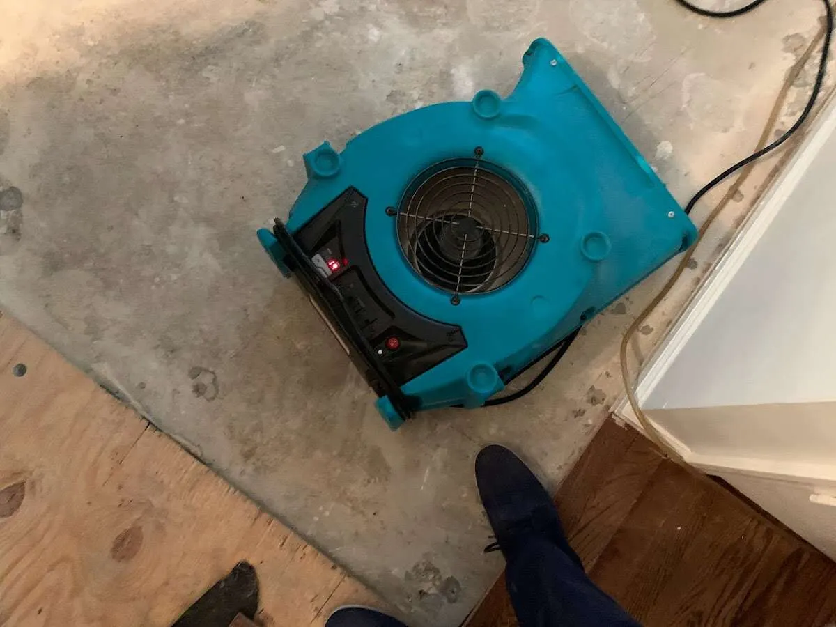 Air mover drying subfloor during Commercial Water Damage Restoration in Girard